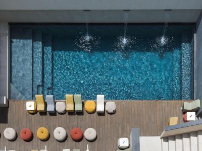 Piscina dall'alto, sedie colorate e atmosfera rilassante.