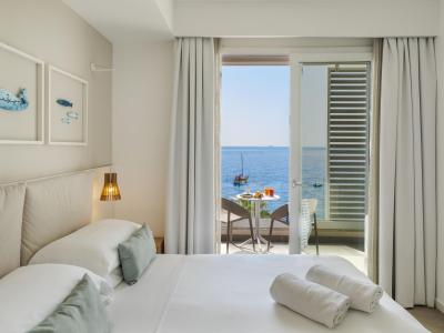 Camera luminosa con vista mare, arredi eleganti e atmosfera rilassante.