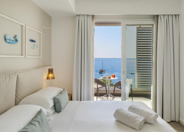 Camera luminosa con vista mare, arredi eleganti e atmosfera rilassante.